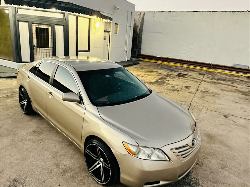 gold sedan on aftermarket wheels outside El Chulo Exotic Cars in Jacksonville